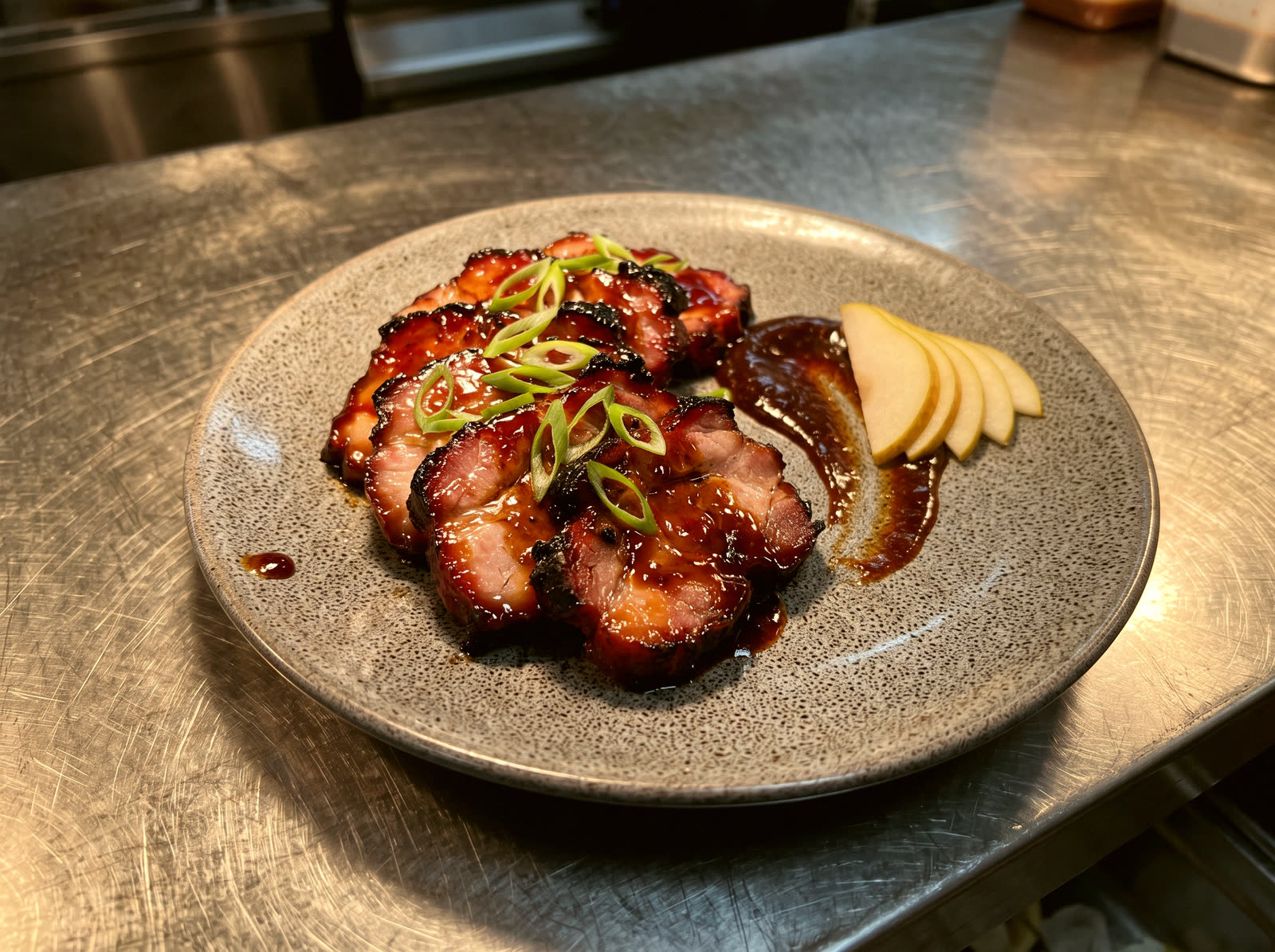 Sliced glazed pork with a dark sauce, fresh pear slices and scallion on a grey plate